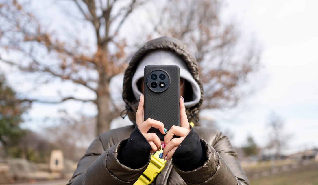 a woman in hoodie holding fiberborne oneplus 13 with aramid fiber case